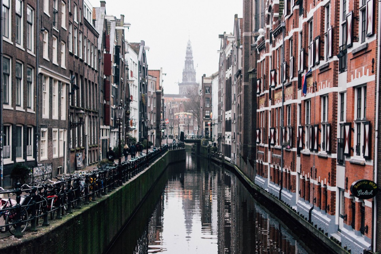 A misty central Amsterdam canal with a church tower, near the Anne Frank House and the dessert spots at Ruma