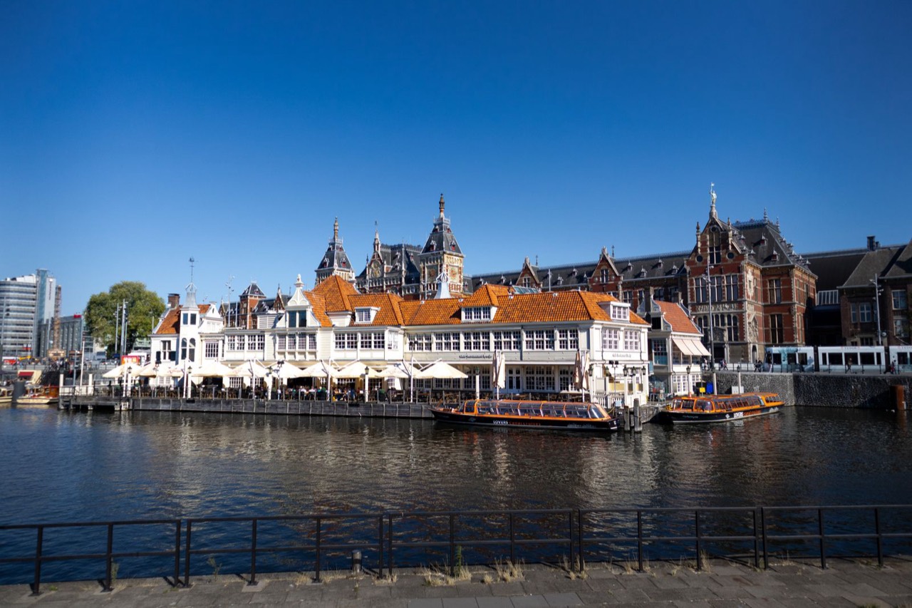 Amsterdam Centraal station seen across the water, near the dessert spots at Ruma